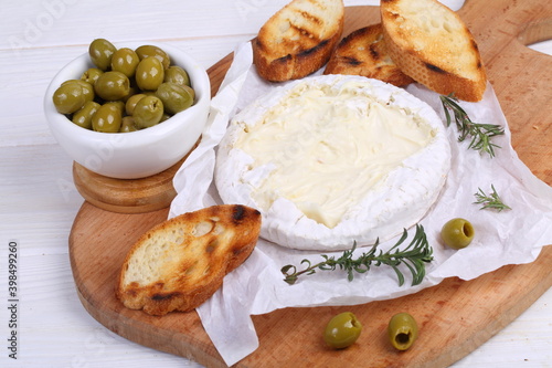 Camembert with toasted baguette on white background