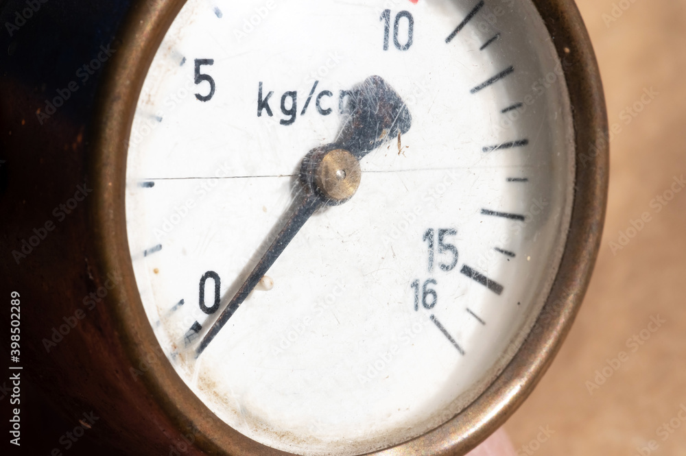 Close-up of an old industrial pressure gauge display with worn protective glass. Macro Close-up of an old industrial pressure gauge display with worn protective glass. Macro