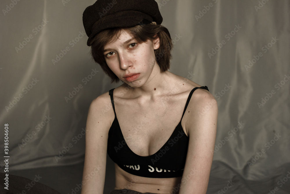 Portrait of a young woman in a top. Model with hat and short hair. Natural clean face Portrait of a young woman in a top. Model with hat and short hair. Natural clean face