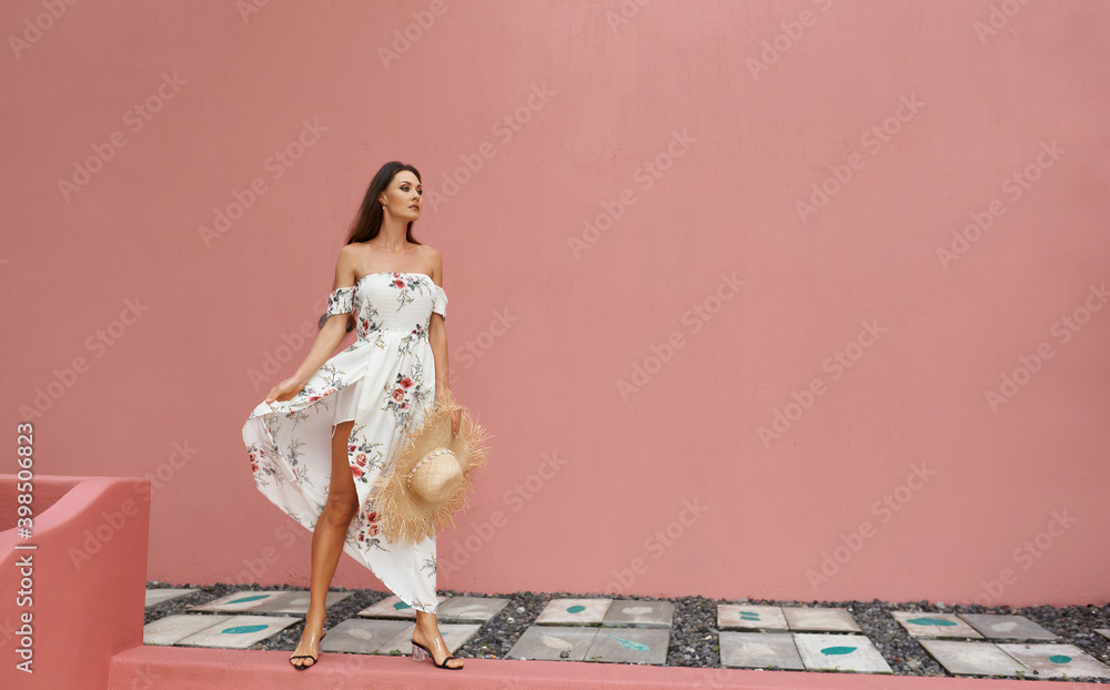 Carefree European girl posing on the street against a pink wall. Funny and positive woman with a hat, having fun. Carefree European girl posing on the street against a pink wall. Funny and positive woman with a hat, having fun.