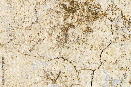 Grunge background of cracked peeling walls with peeled putty in beige tones © yanik88