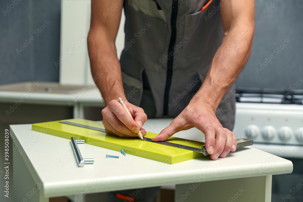 furniture assembler assembles a kitchen cabinet. men hands install new furniture close-up. furniture assembling service concept furniture assembler assembles a kitchen cabinet. men hands install new furniture close-up. furniture assembling service concept