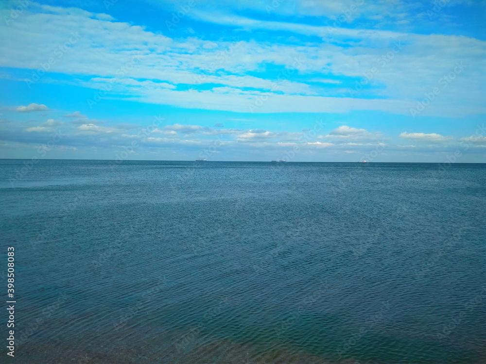 Sea view with cargo ships floating in the distance. Sea view with cargo ships floating in the distance.