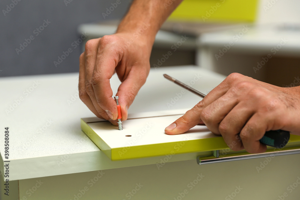 furniture assembler assembles a kitchen cabinet. men hands install new furniture close-up. furniture assembling service concept furniture assembler assembles a kitchen cabinet. men hands install new furniture close-up. furniture assembling service concept