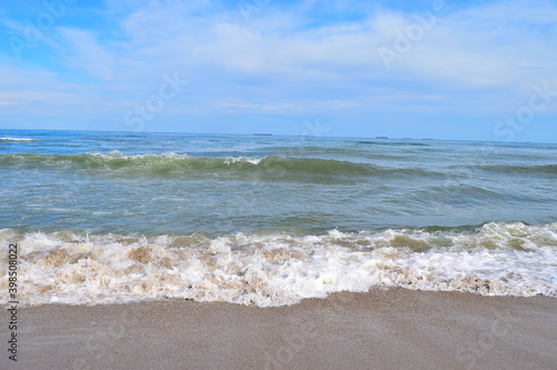 Sea view with cargo ships floating in the distance.