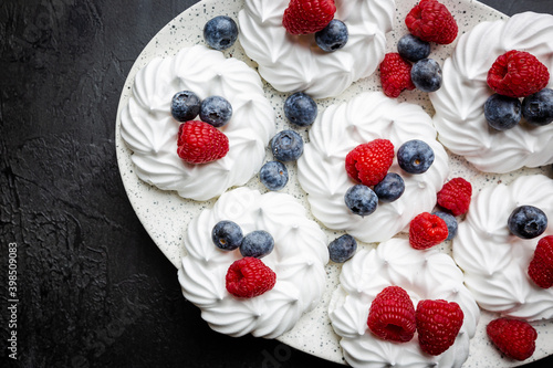 White meringues cakes with berries, raspberry and blueberry. Flat lay, top view