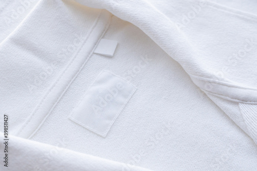 Blank white clothes label on new shirt background