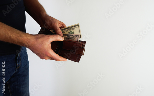 Hand holding a banknote in wallet for financial, accounting and saving money concept. Person holding wallet on a white background.