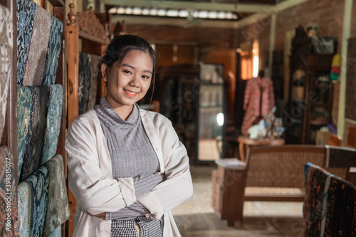 portrait of young customer service in traditional indonesian batik store