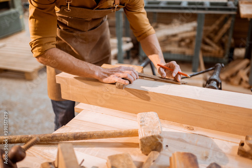 Carpenter working with a wood indoors