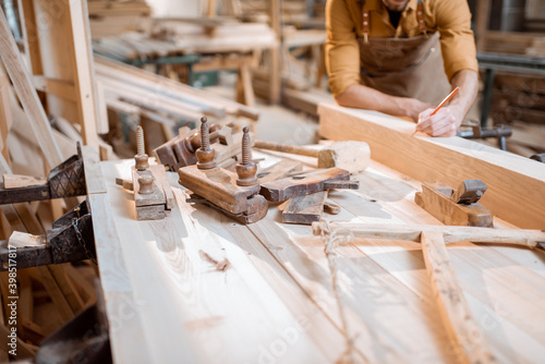 Carpenter working with a wood indoors