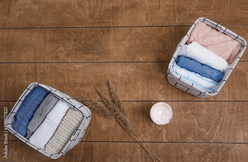 A group of organic cotton clothing laid out on a wooden background is ready to be folded into white baskets.The concept of closet organization.using the komari method. photo