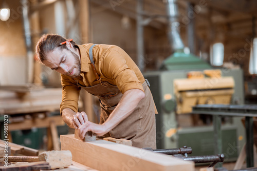 Fotografie Carpenter working with a wood in the workshop