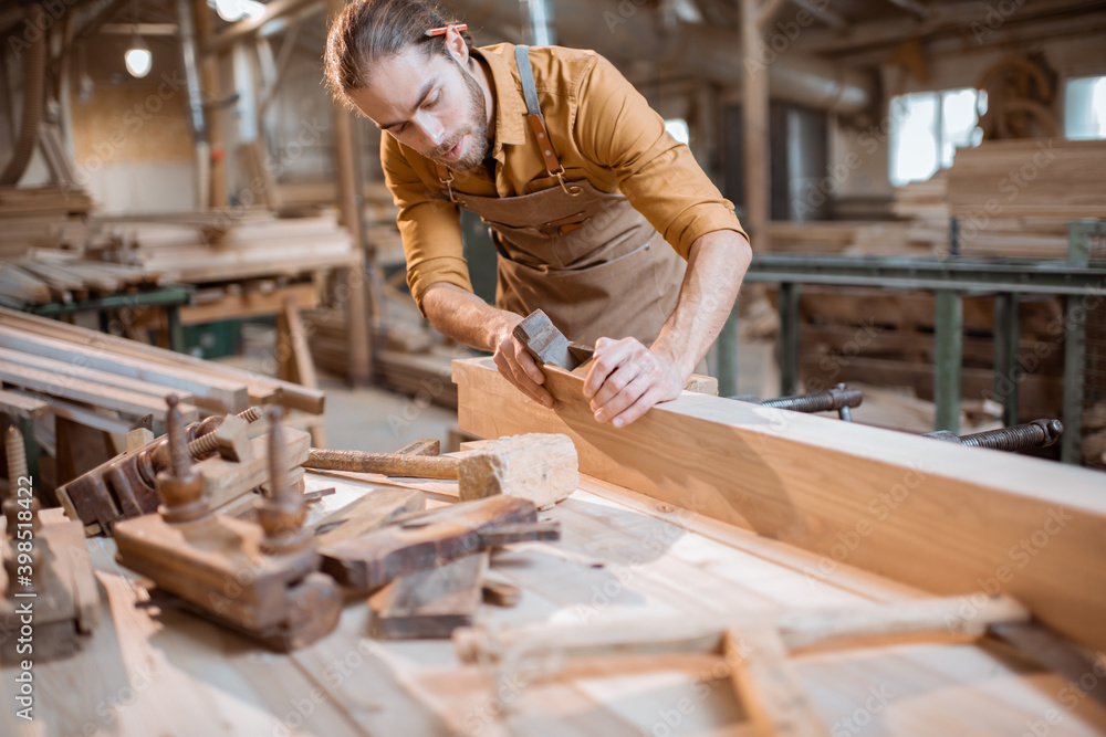 Carpenter working with a wood in the workshop Carpenter working with a wood in the workshop