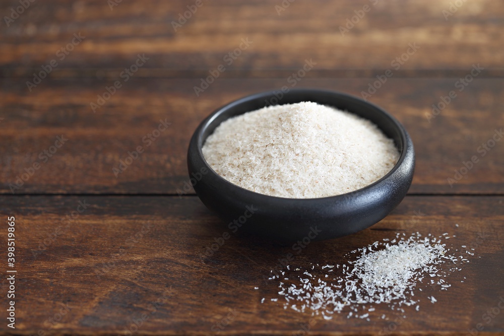 Psyllium hask in a black ceramic bowl. Dark concrete background Psyllium hask in a black ceramic bowl. Dark concrete background