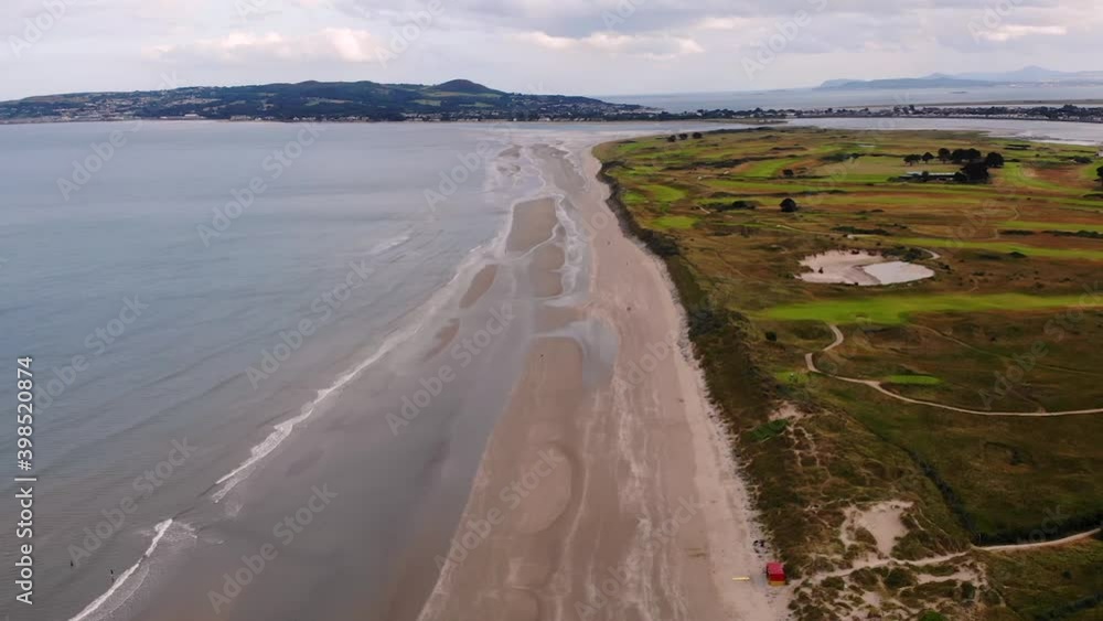 Portmarnock Beach aerial pull back shot. Cloudy day on Ireland coast. Portmarnock Beach aerial pull back shot. Cloudy day on Ireland coast.