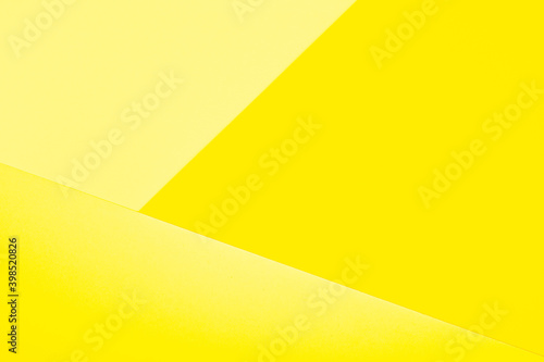 Abstract paper geometric background in shades of yellow. Color of the year 2021 illuminating
