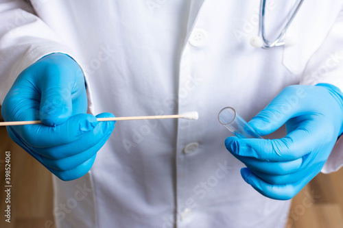 Lab technician holding swab collection kit,Coronavirus COVID-19 specimen collecting equipment,DNA nasal and oral swabbing for PCR polymerase chain reaction laboratory testing procedure and shipping