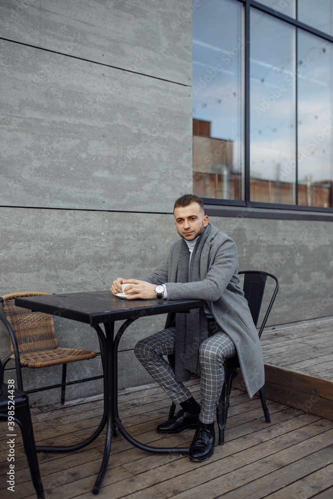 Full length body size photo of man wearing plaid suit grey coat drinking coffee in cafe