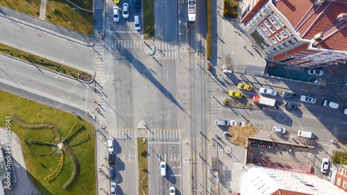 Aerial view of the city traffics at the center. Vehicles are moving on the road between buildings. © abu