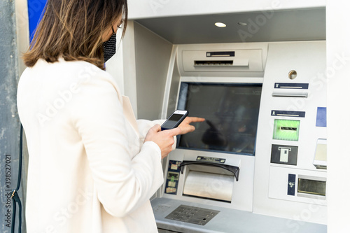 Wallpaper Mural Female entrepreneur withdrawing money from ATM during COVID-19 Torontodigital.ca