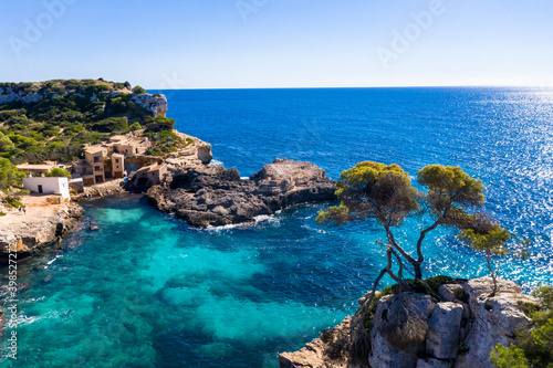 Spain, Mallorca, Santanyi, Helicopter view of coastal village surrounded by blue waters of Mediterranean Sea in summer photo