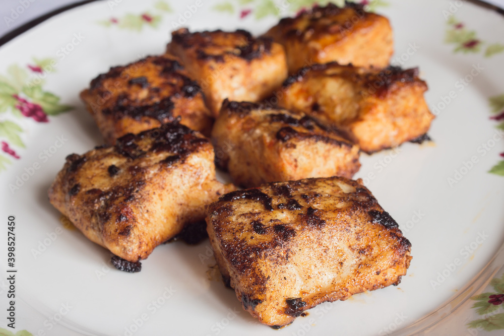 Food plate of hake loins with lemon sauce, garlic, paprika, and butter.