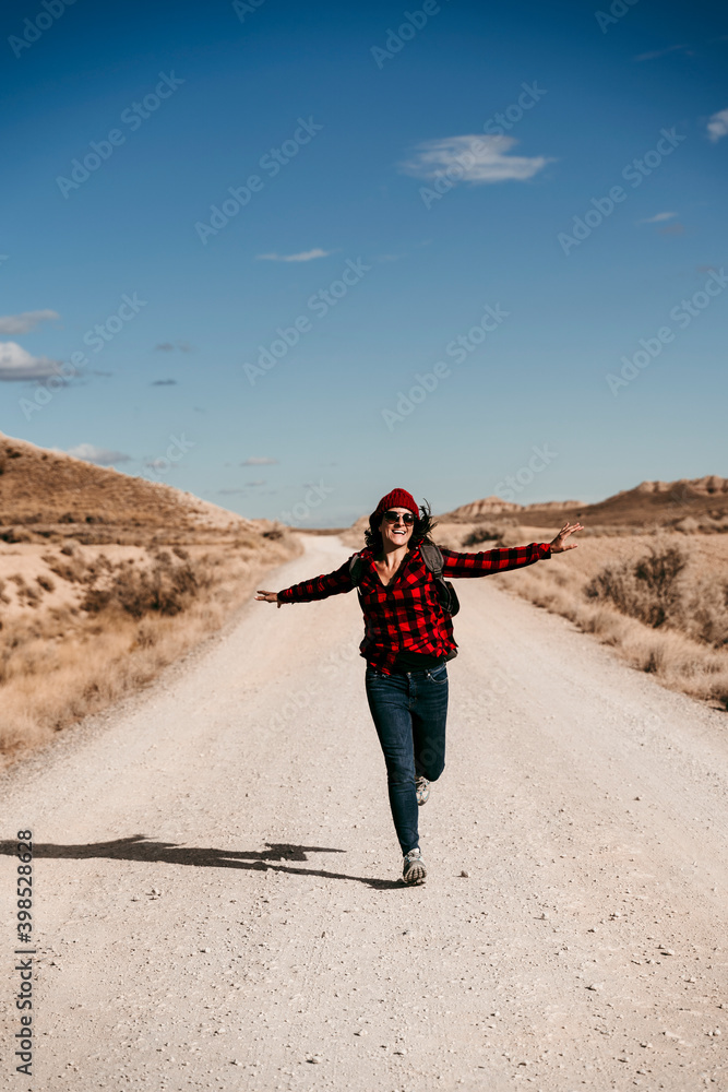 Spain, Navarre, Female tourist running toward camera along empty dirt road inÔøΩBardenasÔøΩReales Spain, Navarre, Female tourist running toward camera along empty dirt road inÔøΩBardenasÔøΩReales