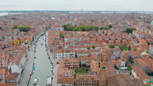 aerial view of Venice in daytime, drone is flying over amazing italian city, red roofs and canal