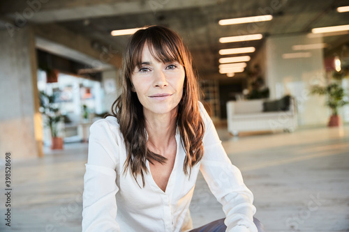 Thoughtful mature woman sitting at home photo