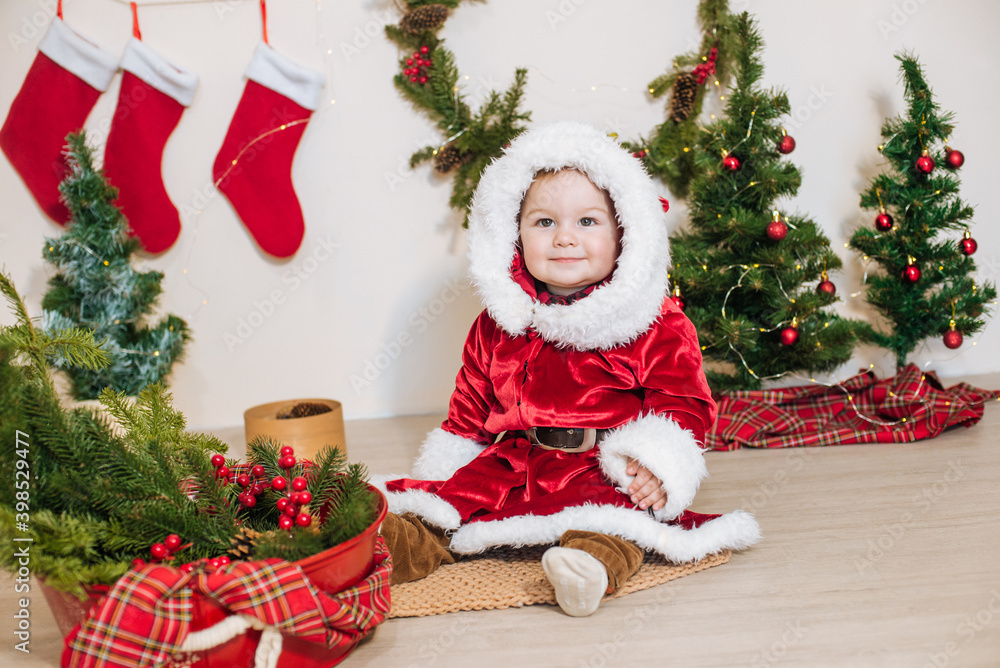 Little cute boy dressed as Santa near little Christmas trees. Christmas mood Little cute boy dressed as Santa near little Christmas trees. Christmas mood