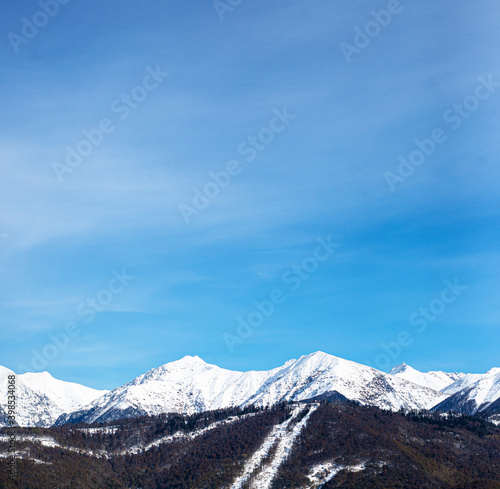  Mountain landscape against the blue sky. Snowy mountain peaks. Copy space for text. Card. Template for an advertisement.