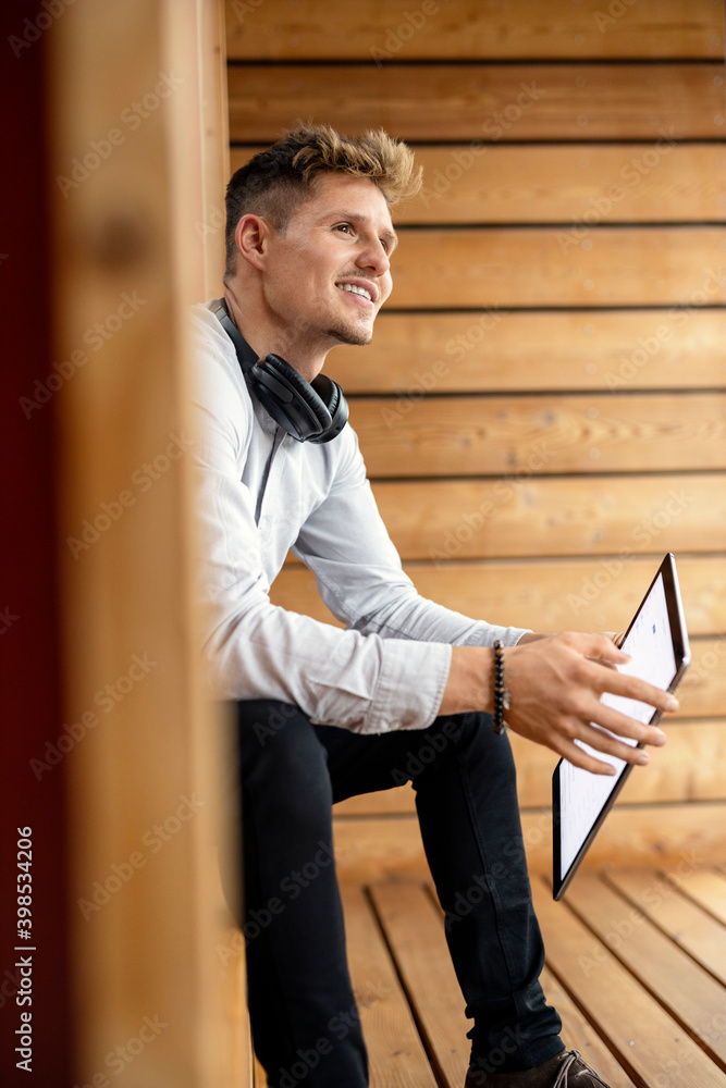 Man with digital tablet looking away while sitting at home Man with digital tablet looking away while sitting at home