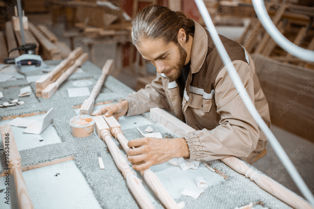 Foto Stock Manual worker finishing wooden products, spackling and ...