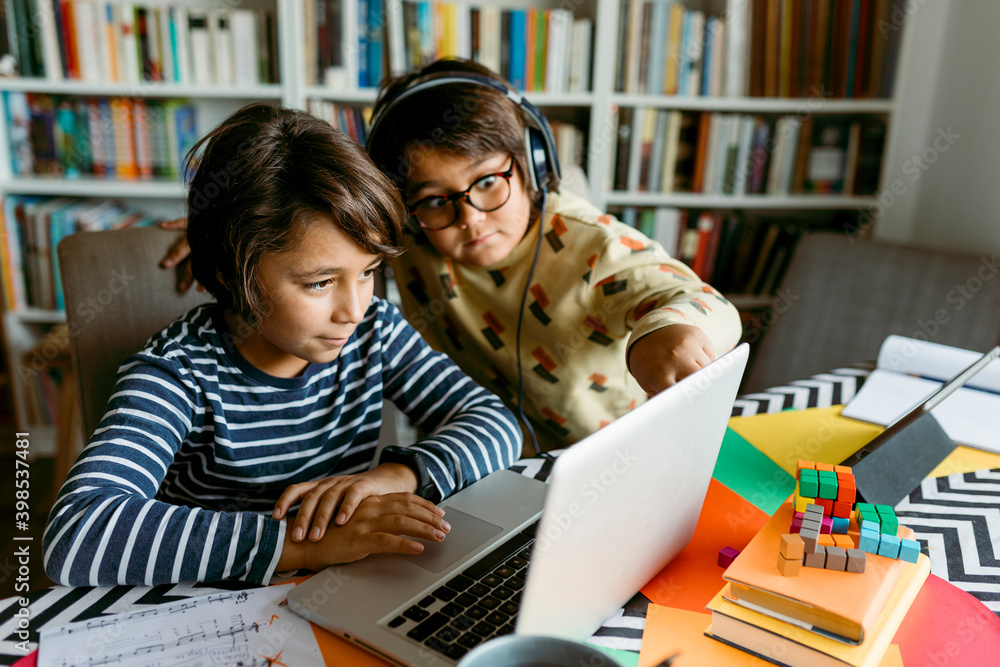 © VALENTINA BARRETO STUDIO/Westend61 - Boys looking at laptop while e-learning in living room © VALENTINA BARRETO STUDIO/Westend61 - Boys looking at laptop while e-learning in living room