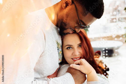 Portrait of happy couple cuddling, loving African American man hold a hand of pregnant beautiful woman, caring husband with lovely wife enjoy tender moments, young family concept
