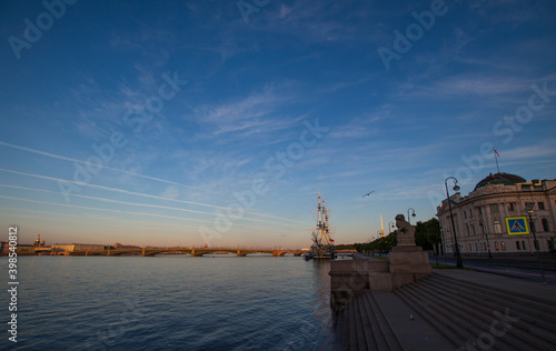 Summertime morning view of the frigate nearby Petrovskaya embankment, Neva river and the Trinity Bridge with blue sky background. St. Petersburg, Russia.