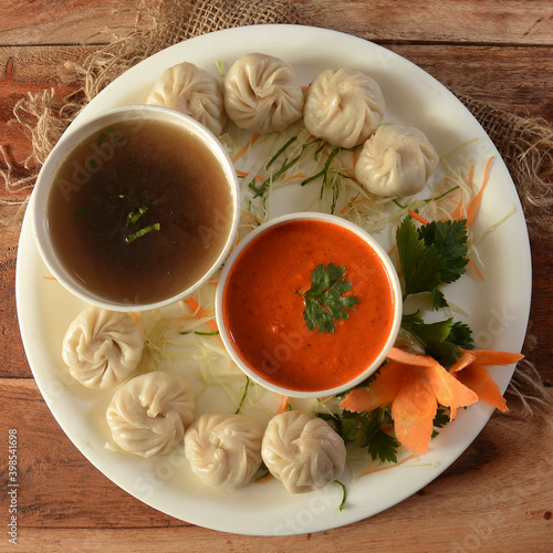 Combo of Veg steam momo and veg soup, Nepalese Traditional dish Momo stuffed with vegetables and then cooked and served with sauce over a rustic wooden background, selective focus