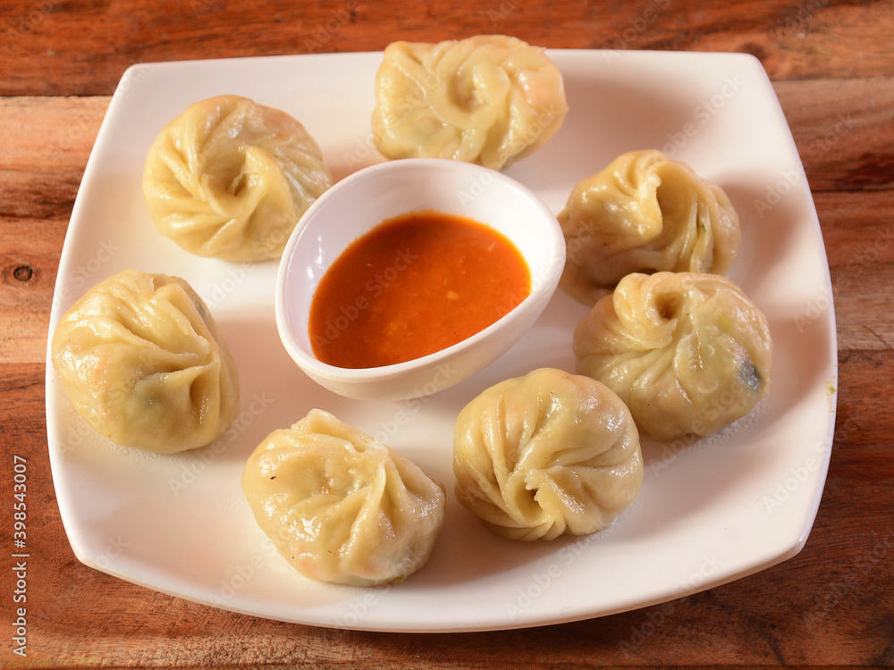 Veg steam momo. Nepalese Traditional dish Momo stuffed with vegetables and then cooked and served with sauce over a rustic wooden background, selective focus Veg steam momo. Nepalese Traditional dish Momo stuffed with vegetables and then cooked and served with sauce over a rustic wooden background, selective focus