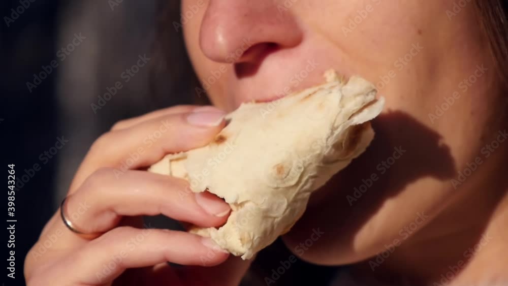Woman eating vegetable shawarma in instant pita bread with desire