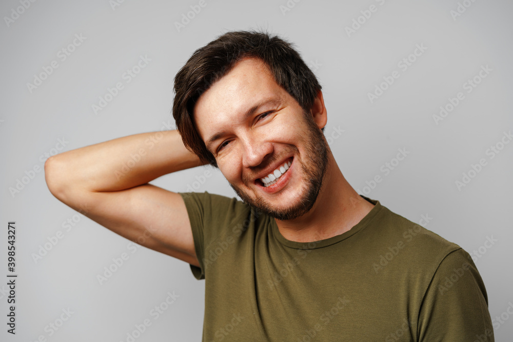 Handsome young man portrait smiling against grey background Handsome young man portrait smiling against grey background