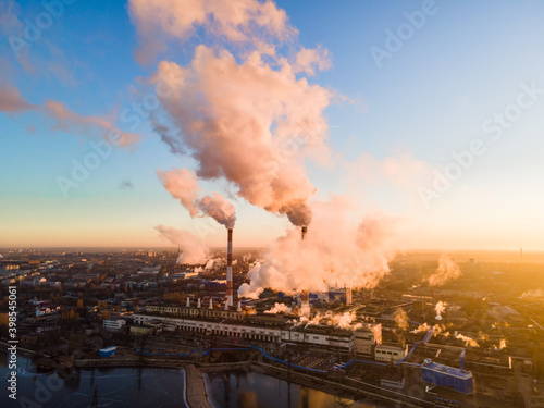 Aerial view of high smoke stack with smoke emission. Plant pipes pollute atmosphere. Industrial factory pollution, smokestack exhaust gases. Industry zone, thick smoke plumes. Climate change, ecology