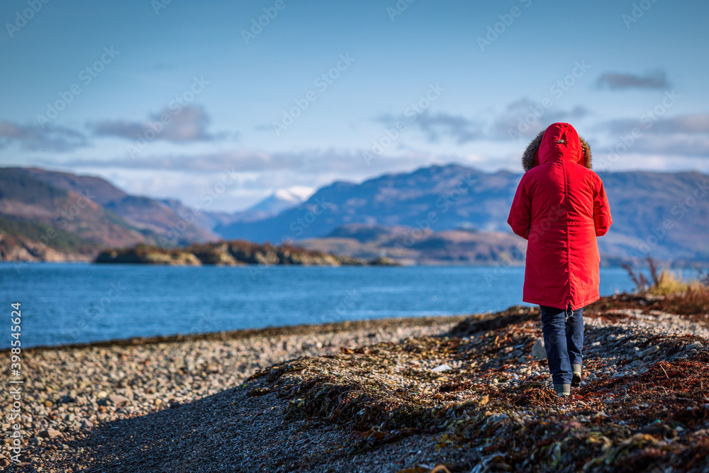 Walker on the shore near Kyleakin Isle of Skye Scottish Highland and Islands