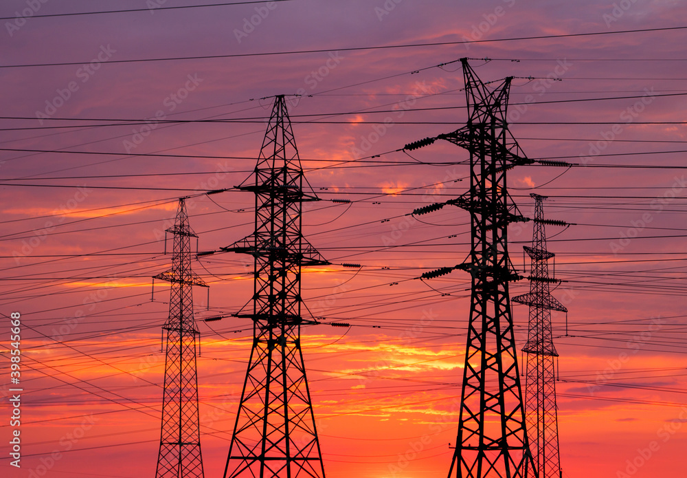 Electric pole silhouettes with purple sunset sky background.