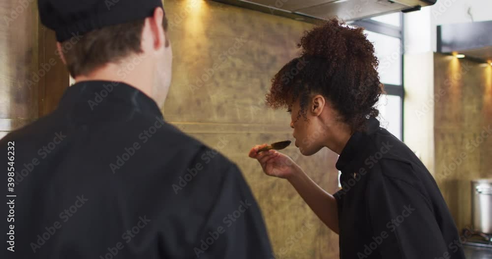 Mixed race female chef preparing a dish and smiling in a kitchen Mixed race female chef preparing a dish and smiling in a kitchen