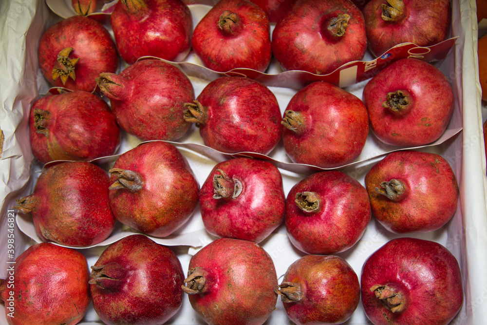Grenades in a box stacked in rows of bright red color. Fruits vegetables berries useful products agriculture. Grenades in a box stacked in rows of bright red color. Fruits vegetables berries useful products agriculture.