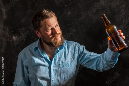 Solid bearded man in shirt with bottle of beer