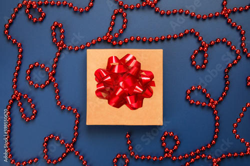 Merry Christmas and Happy Holidays image of gift box with red bow and ball garland