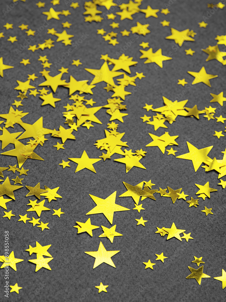 Ultimate gray background with illuminating golden stars sequins. Copy space for text. Christmas time or New Year abstract background in main colours of the year 2021. Concept of winter holiday. Ultimate gray background with illuminating golden stars sequins. Copy space for text. Christmas time or New Year abstract background in main colours of the year 2021. Concept of winter holiday.
