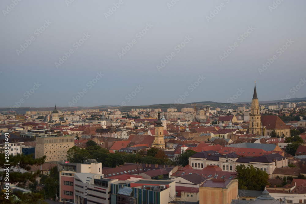 Cluj-Napoca,Romania- 07.20.2019: Aerial photography over the town center at the sunset. Sfantul Mihail Church,located in the center of the city,in Matei Corvin Square (Mathias Rex).